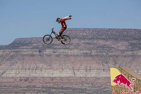 Freeride mountainbiker fietst vanaf schans lucht in zonder handen aan stuur