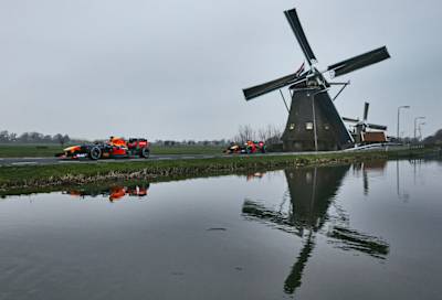 A photo of Red Bull Racing's F1 cars alongside Dutch windmills