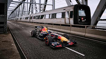 David Coulthard rast während des Scandi Road Trip in Dänemark am 23. August 2023 über die Alte Brücke über den Kleinen Belt, während ein Zug vorbeifährt