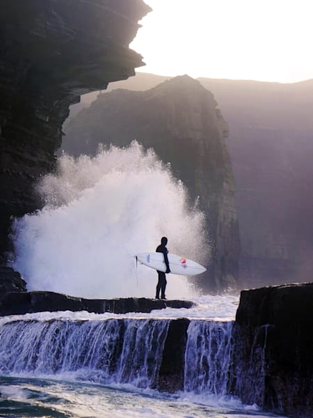 El surfista irlandés Conor Maguiere sobre una roca.