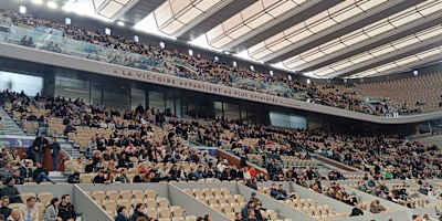 Les spectateurs prennent place sous les aile du toit du court Philippe-Chatrier à Roland-Garos.