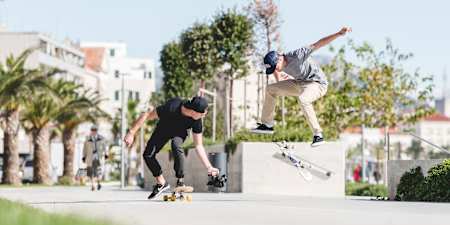 A skateboarder gets video recorded by a cameraman on a skateboard