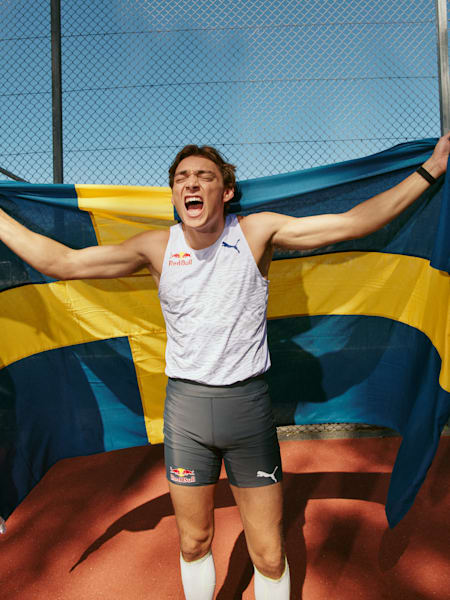 Le perchiste Armand 'Mondo' Duplantis célèbre sa victoire lors d'une compétition de saut à la perche avec le drapeau suédois.