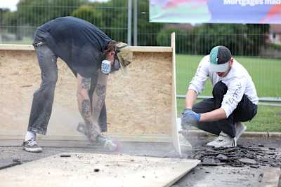 Two skate park builders from Skate Nottingham working on a wooden skate ramp 