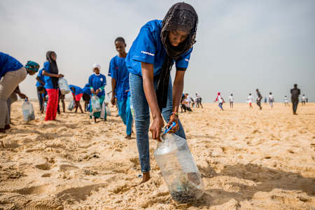 A volunteer collects plastic waste to make an ecobrique, which can then be used in building construction.