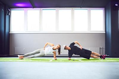 Deux partenaires d'entraînement font du sideplanking.