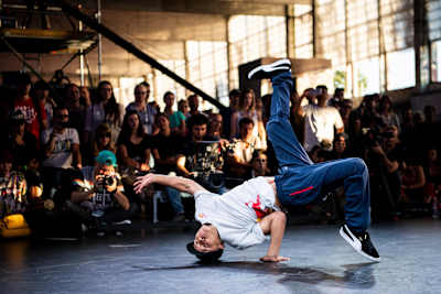 Shigekix balances on his head and one hand