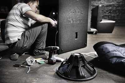A technician sets up a speaker as part of a sound system for an event.