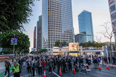 Spectators in the street pause to watch the Red Bull Air Force Team wingsuit through Downtown Los Angeles, CA, USA on March 20, 2019.