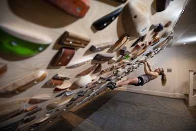 Competitive climber Shauna Coxsey showcases her skills using the climbing wall in the basement of her house.