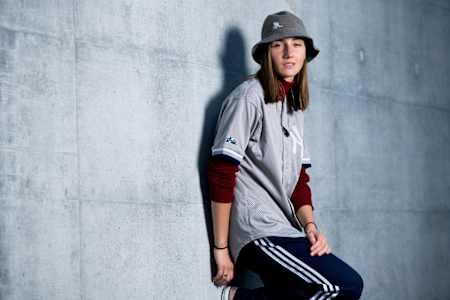 Kastet lehnt an einer Wand und trägt Adidas mit Kangol kombiniert