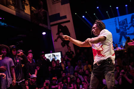 Neguin gesturing towards his opponents during a battle.