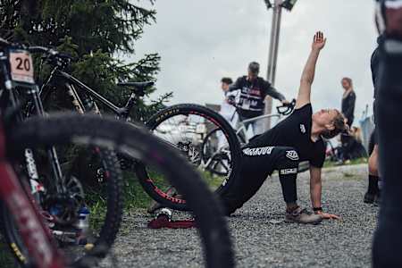 Foto von Lokalmatadorin und Mountainbike-Profi Vali Höll beim Stretching vor dem Downhill-Rennen in Leogang 2021.