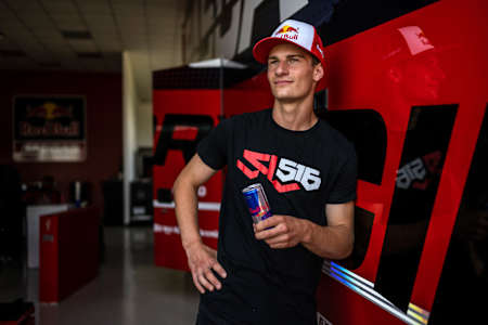 Motocross-Ass Simon Längenfelder steht mit einer Red Bull Dose in der Hand für ein Porträtfoto parat.