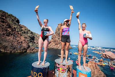 Rhiannan Iffland (C), Molly Carlson (L) and Jessica Macaulay celebrate after winning the first stop of the Red Bull Cliff Diving World Series in Saint Raphael, France on June 12, 2021.