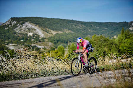 Daniela Ryf rides her Felt bike in France with a backdrop of tree covered mountains.