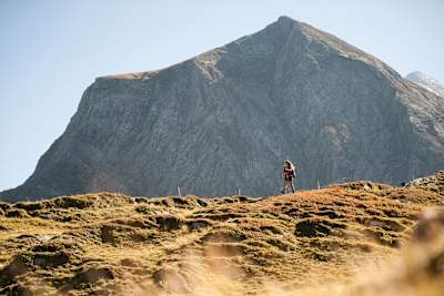 Walker on fell with big mountain backdrop in Austria.