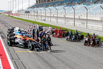 20 kierowców Formuły 1 pozujących do wspólnego zdjęcia na prostej startowej toru w Bahrajnie przed startem sezonu 2021