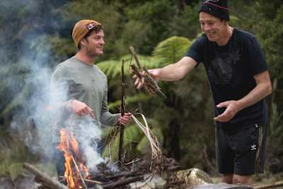 Rob Warner and Matt Jones build a fire at their wilderness camp in the Buller District of New Zealand.