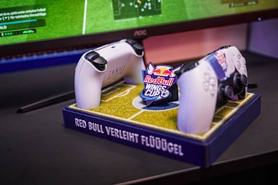 Foto von der Messe Graz zeigt zwei PlayStation-5-DualSense-Controller mit dem Red Bull Wings Cup-Logo und EA Sports FC 27 im Hintergrund.