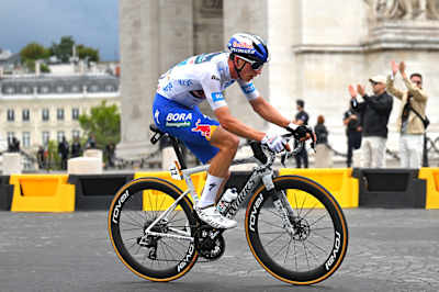 Ciclistul german Florian Lipowitz de la Red Bull - BORA - hansgrohe traversează Parisul la Tour de France 2025.