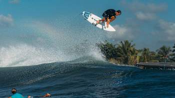 Surfer Julian Wilson performs a huge alley-oop aerial while surfing in Bali