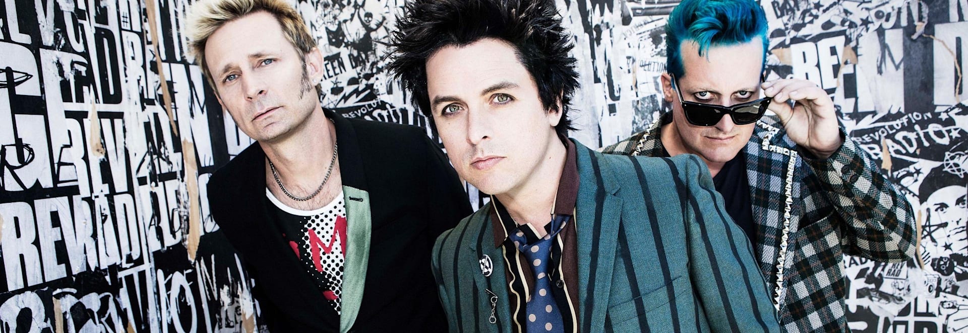 Banda Green Day, sobre fondo oscuro, con los ojos pintados de negro