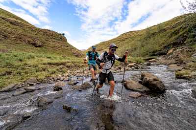 Ryan Sandes and Ryno Griesel running through a small river during the Trail Running project Navigate Lesotho in April 2022