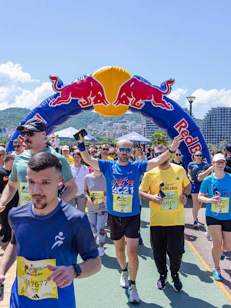 Participants cross under the Red Bull arch during the Wings For Life World Run app run in Tirana, Albania, on May 5, 2024, with vibrant energy and a supportive crowd