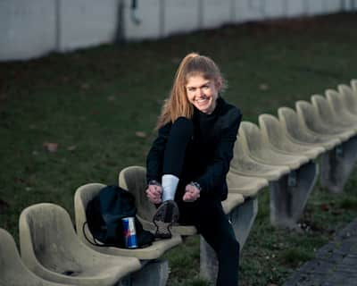 Konstanze Klosterhalfen, l'as de la course à pied, lace ses chaussures de sport avant son entraînement.