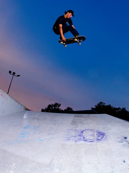 Floating a Frontside grab through the twilight skies above Perry Lakes skatepark in Perth, Australia