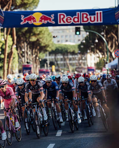 Riders pass under the arch of the Red Bull KM during the last stage of the Giro d'Italia 2025 in Rome, Italy.