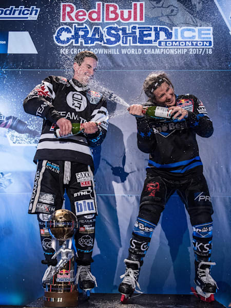 Male and female World Champions Scott Croxall of Canada and Amanda Trunzo of the USA celebrate with champagne at Red Bull Crashed Ice in Edmonton, Canada on March 10, 2018.