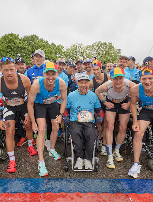 A wave of determined athletes and wheelchair participants gather at the start line of the 2025 Wings for Life World Run in Munich, Germany, embodying Red Bull's drive for inclusivity and adventure