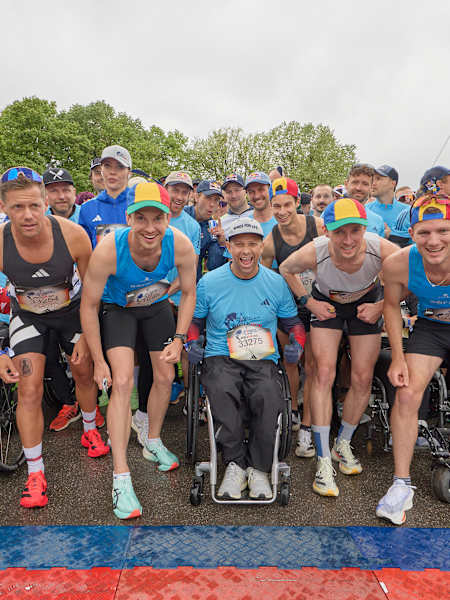 A wave of determined athletes and wheelchair participants gather at the start line of the 2025 Wings for Life World Run in Munich, Germany, embodying Red Bull's drive for inclusivity and adventure