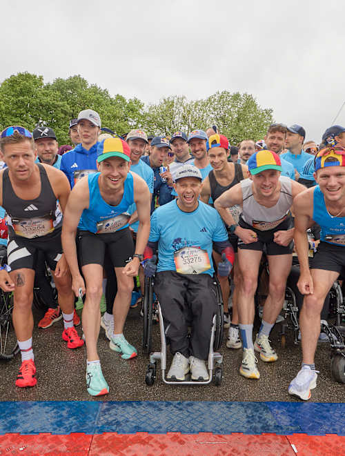A wave of determined athletes and wheelchair participants gather at the start line of the 2025 Wings for Life World Run in Munich, Germany, embodying Red Bull's drive for inclusivity and adventure