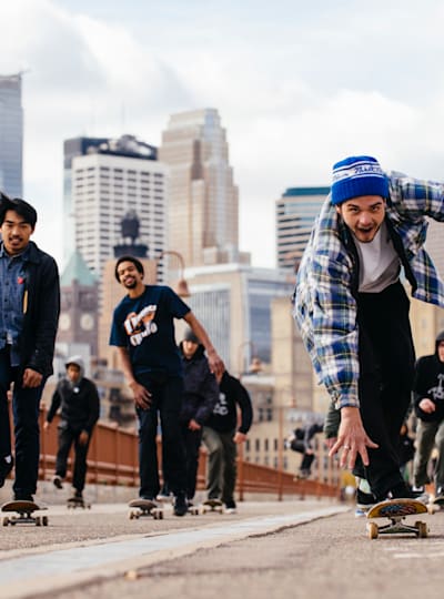 Skaters cross the Stone Arch Bridge for Red Bull Interskate in Minneapolis
