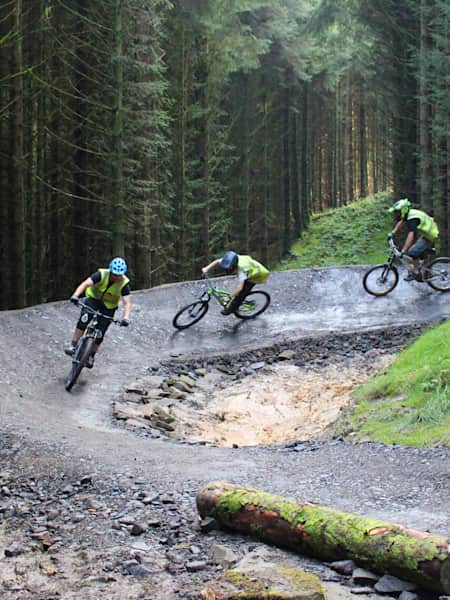 Quattro biker attraversano il sentiero Sixtapod al BikePark Wales.