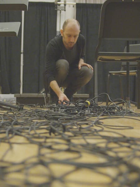 Tristan Perich adjusting cables at the rehearsals for Drift Multiply,