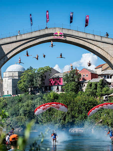 On 4 September 2025, nine athletes dive from Mostar’s 21-metre Stari Most as Red Bull Skydive Team athletes Marco Fürst and Marco Waltenspiel fly beneath them