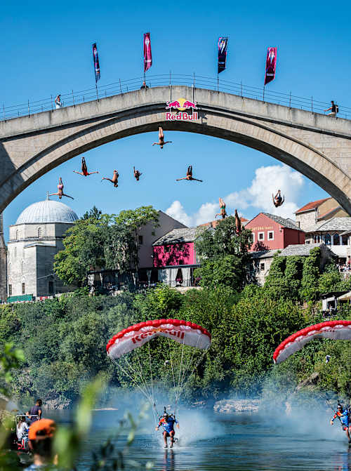 On 4 September 2025, nine athletes dive from Mostar’s 21-metre Stari Most as Red Bull Skydive Team athletes Marco Fürst and Marco Waltenspiel fly beneath them