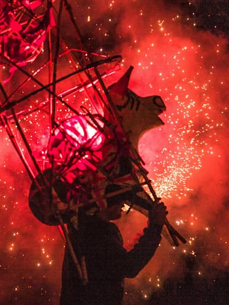 La luz del fuego crea la ilusión de un toro rojo atravesando la noche