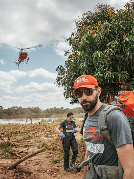 A photograph of a Team Rubicon member on the ground in a disaster zone.