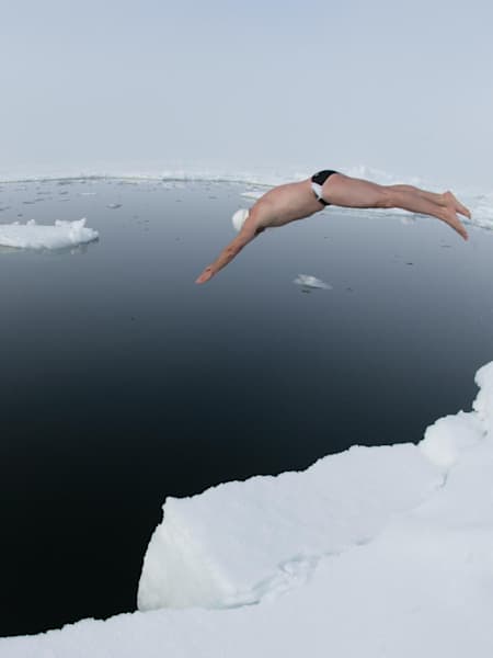 Lewis Pugh jumping into the icy cold water of the North Pole during his historic first long-distance swim at the top of the wolrd