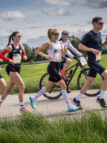 Leni Schömburg-Heuck corre junto a un ciclista en la carrera Wings for Life World Run de Red Bull en Múnich, Alemania.