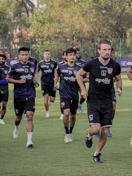 Sports scientist Csaba Gabris and players of Chennaiyin Football Club warm up during a training session.