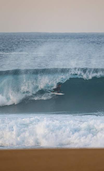 In 2024, surfer Dominique Charrier rides a massive wave barrel at Red Bull's Waves of Consequence event in Nazaré, Portugal.