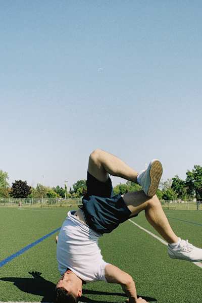 Fléau does a Head Hollow Back on a soccer field.