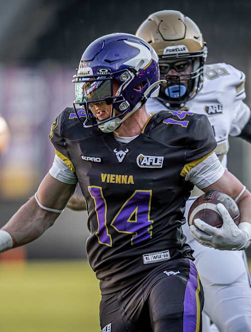 Vienna Vikings player Yannick Mayr runs with the football towards the end zone, chased by the other team