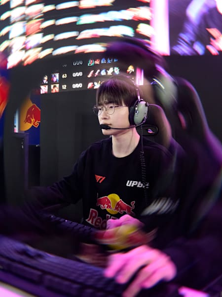 Faker of T1 competes at the Red Bull PC Room Take Over in Seoul, South Korea, on 27 December 2025, focused at his gaming station under vibrant arena lights.
